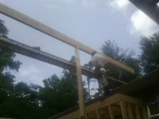 Carpenter setting a ridge beam over a new addition frame — Ice Dam Removal by Roofing Brothers in Hollandale