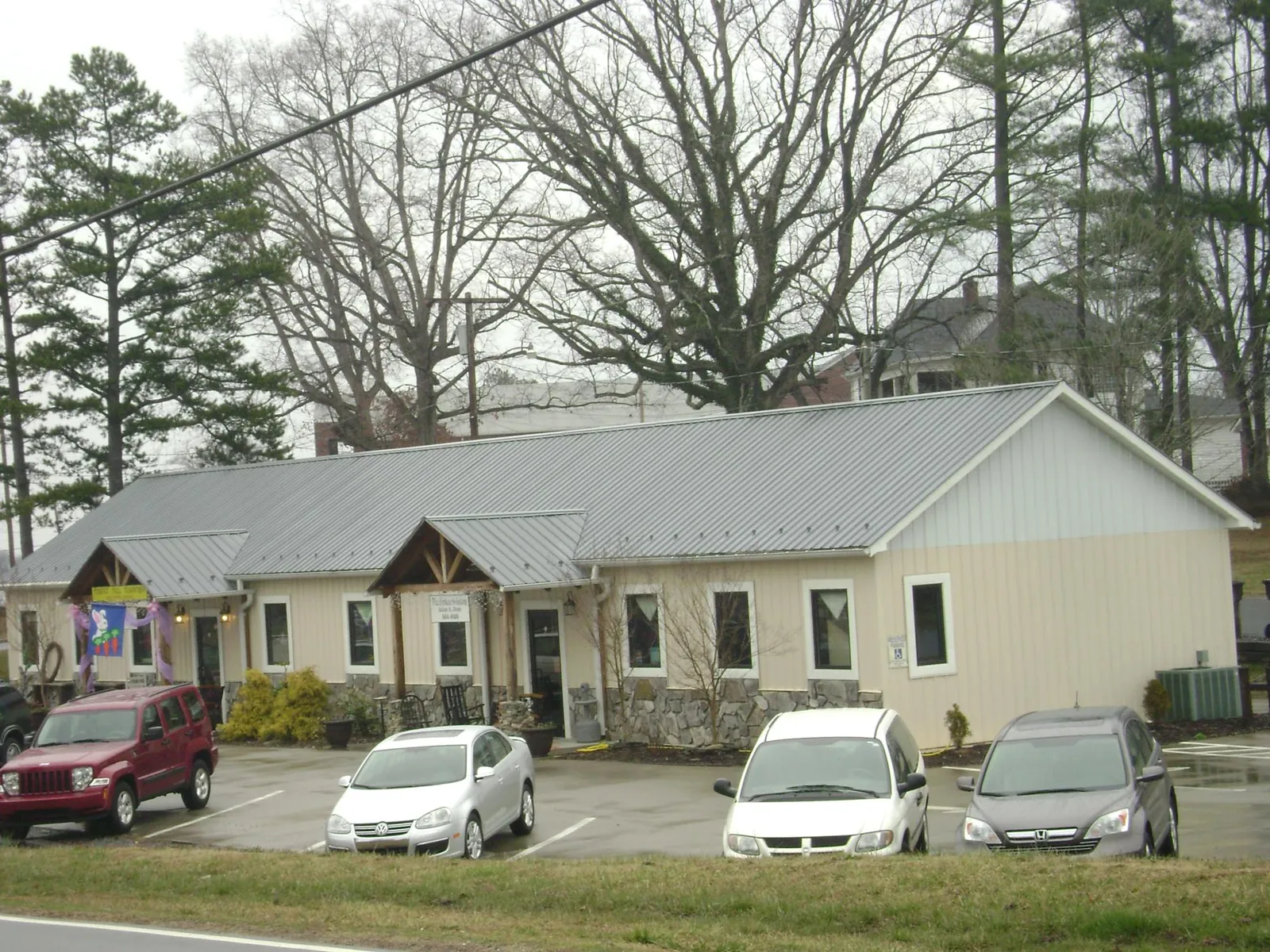 Gray metal roof with timber entry brackets on a small commercial building in Hollandale