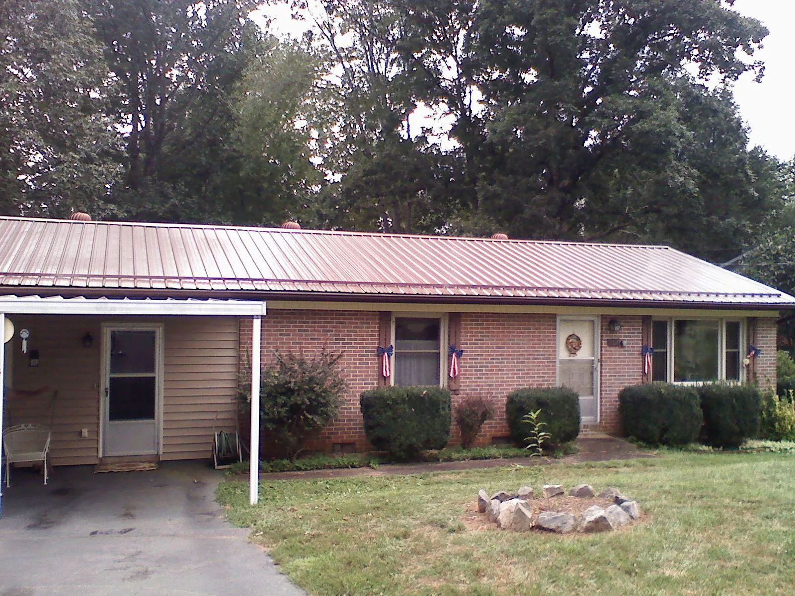 Bronze metal roof and carport on a brick ranch home — Roof Repair work by our crew in Hollandale
